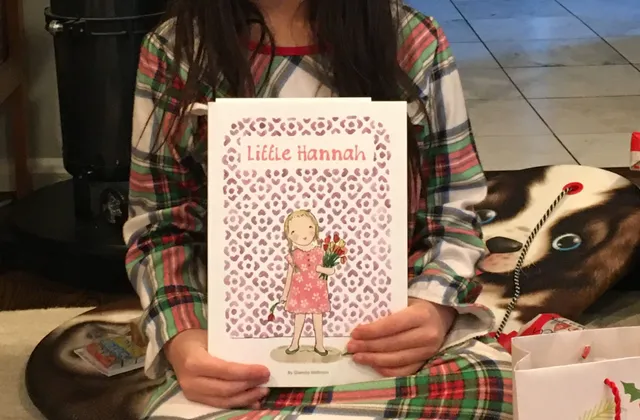 A little girl holding her copy of Little Hannah