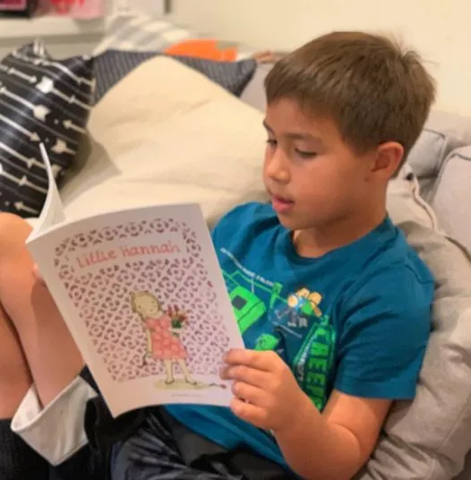 A young boy reading Little Hannah