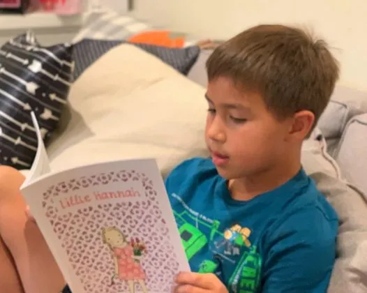 A young boy reading Little Hannah